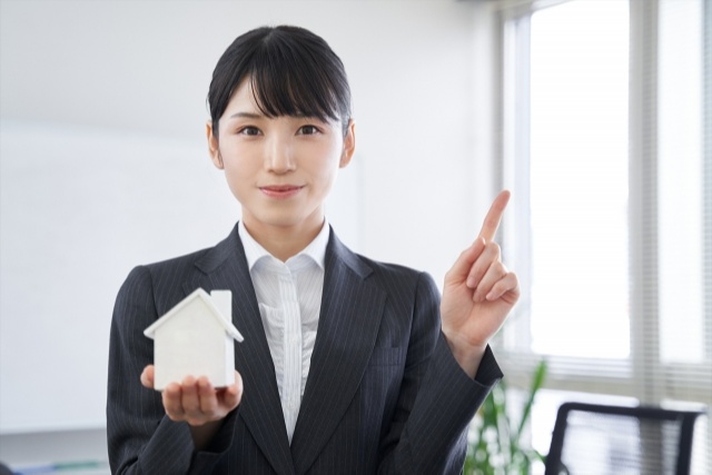 指を立てるスーツの女性