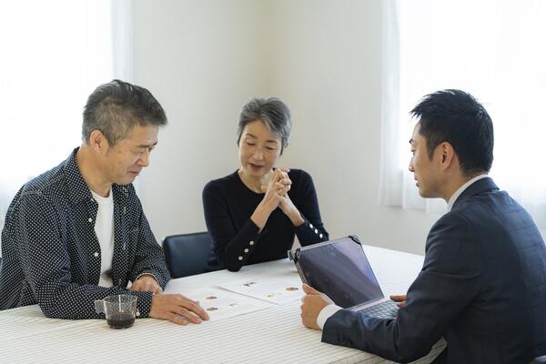 不動産売買・査定について話し合う夫婦と男性